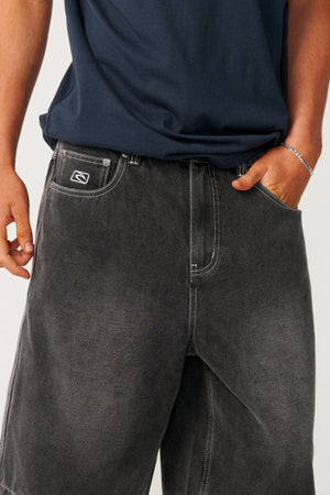 Rip Curl Archive Dirty Denim Walkie Walkshorts in a relaxed baggy fit, made from faded black denim with white contrast stitching and a small logo on the coin pocket.