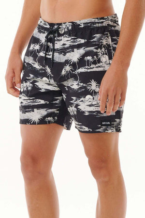 Someone is sporting the Rip Curl Dreamers Volley board shorts, featuring a black and white tropical design with an all-over print of palm trees and island patterns. These stylish swim shorts come with a drawstring and are made from recycled fabric, aligning with eco-conscious fashion values.