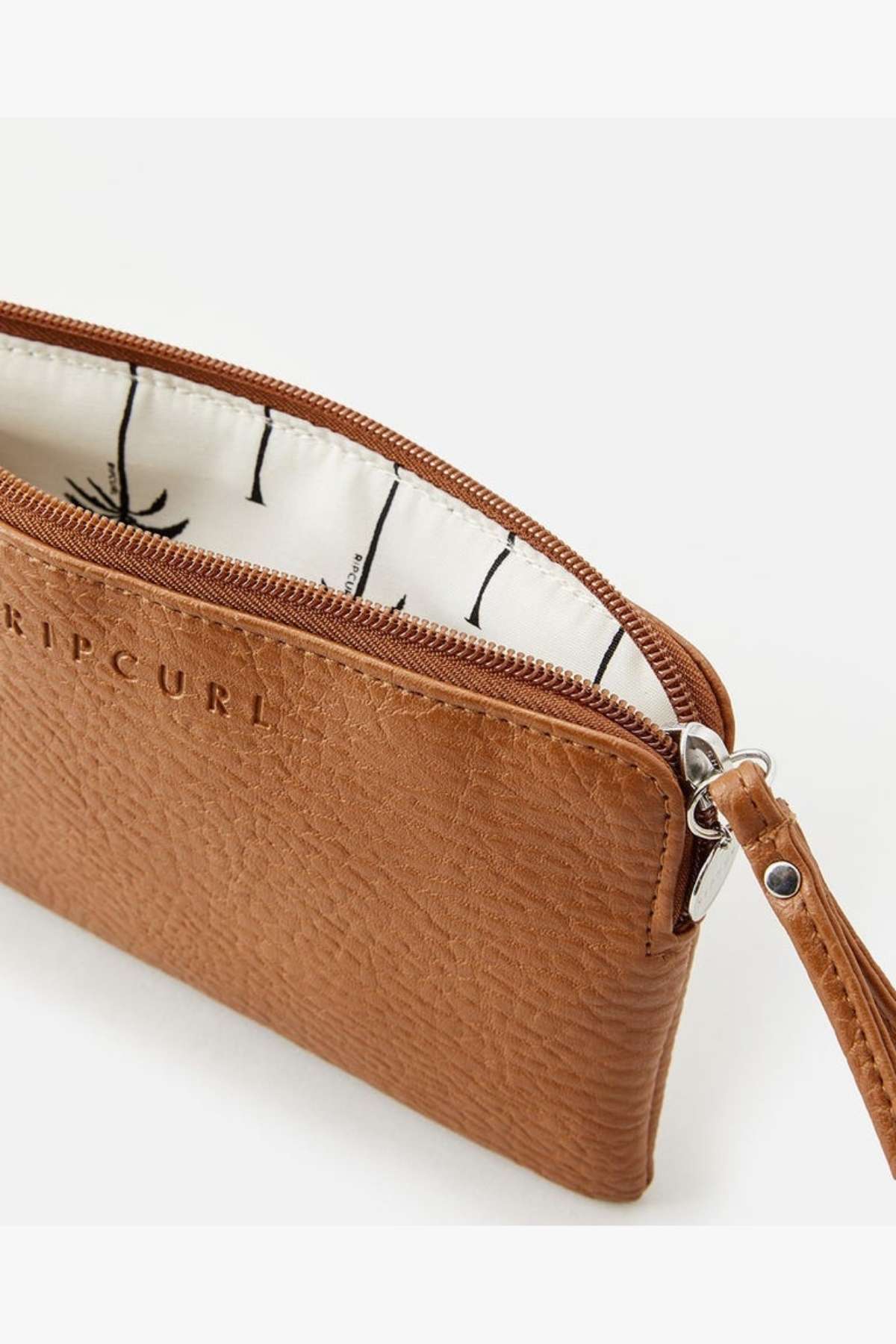 The Rip Curl Essentials 2 Wristlet, made from brown faux-leather, showcases a partially open zipper that reveals a subtly patterned light interior. It includes an embossed logo on the front and a small metal clasp on the side, elegantly blending style with practicality.