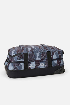 The Rip Curl F-Light Global 100L Search Camo Travel Bag is a large rectangular soft-sided duffel with wheels, made from recycled polyester, featuring a blue and gray camo pattern, black base and handles, shown on a plain white background.