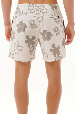 A person is seen from the back wearing the Rip Curl Fun Times Volley shorts, which feature a gray floral and swirl pattern. These white shorts come equipped with quick-dry technology, an elastic waistband, and pockets, making them ideal for water-related activities. The background is a simple white.