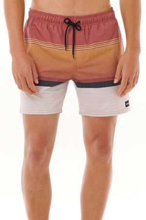 A person is seen wearing the Rip Curl Fun Times Volley swim shorts, featuring a color-block design in shades of red, orange, white, and black. These shorts include quick dry technology and a black drawstring. The image focuses on just their lower torso and legs against a white background.