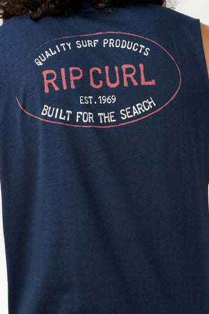 The image showcases the reverse side of a navy blue Rip Curl Hallmark Muscle t-shirt. The shirt features text that reads: "Quality Surf Products, Rip Curl, Est. 1969, Built for the Search" in a white and red design.