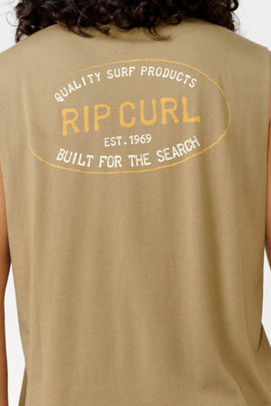 Back view of a person wearing the sleeveless beige Rip Curl Hallmark Muscle top, showcasing white and orange text that reads: "Quality Surf Products, Rip Curl, Est. 1969, Built for the Search," made from 100% cotton.