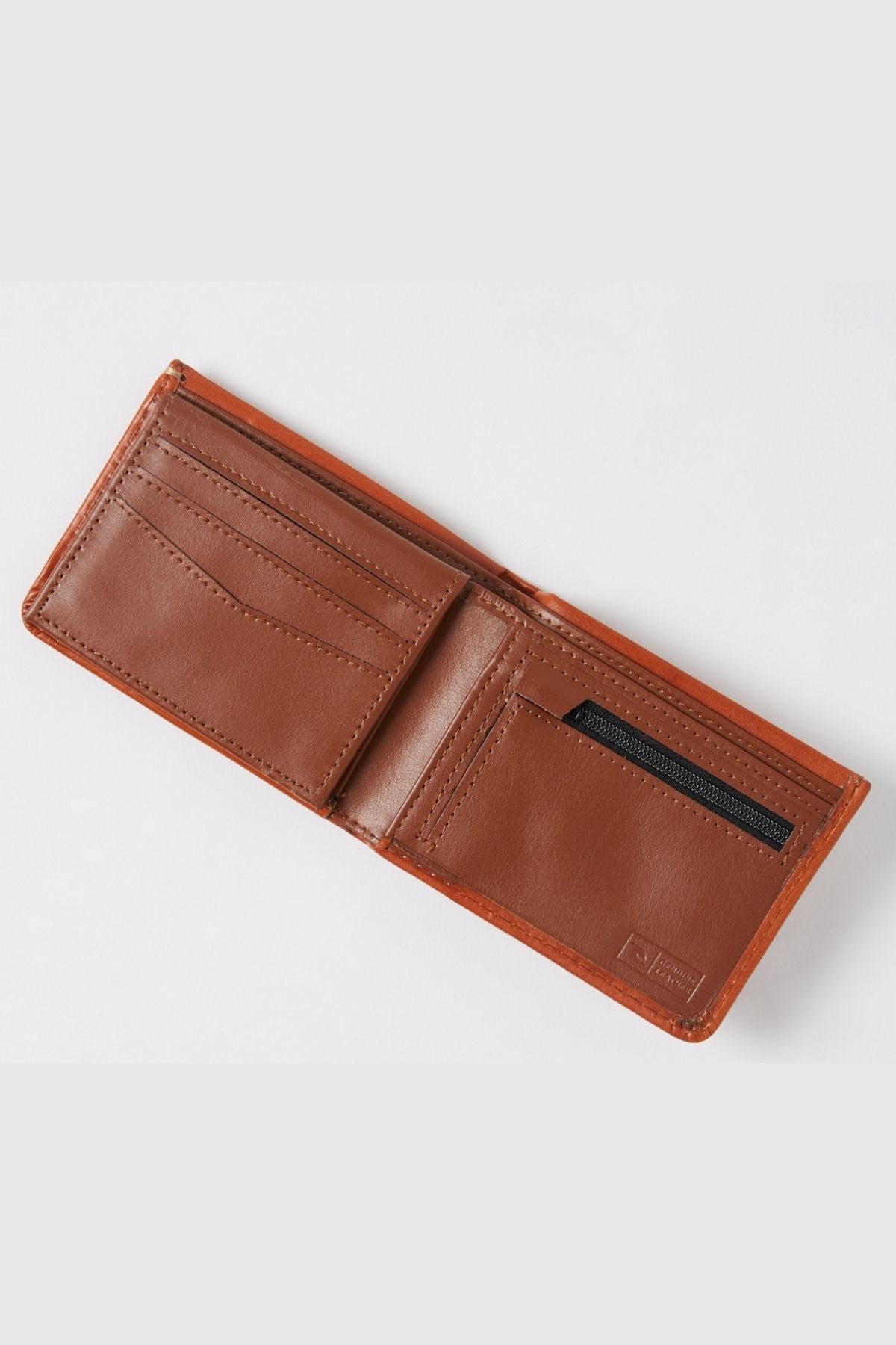 The Rip Curl Hi Rise RFID All Day Wallet, crafted from brown leather, lies open on a white background. It showcases RFID protection, with multiple card slots on the left side and a zippered pocket on the right. A spacious bill compartment stretches across the top.