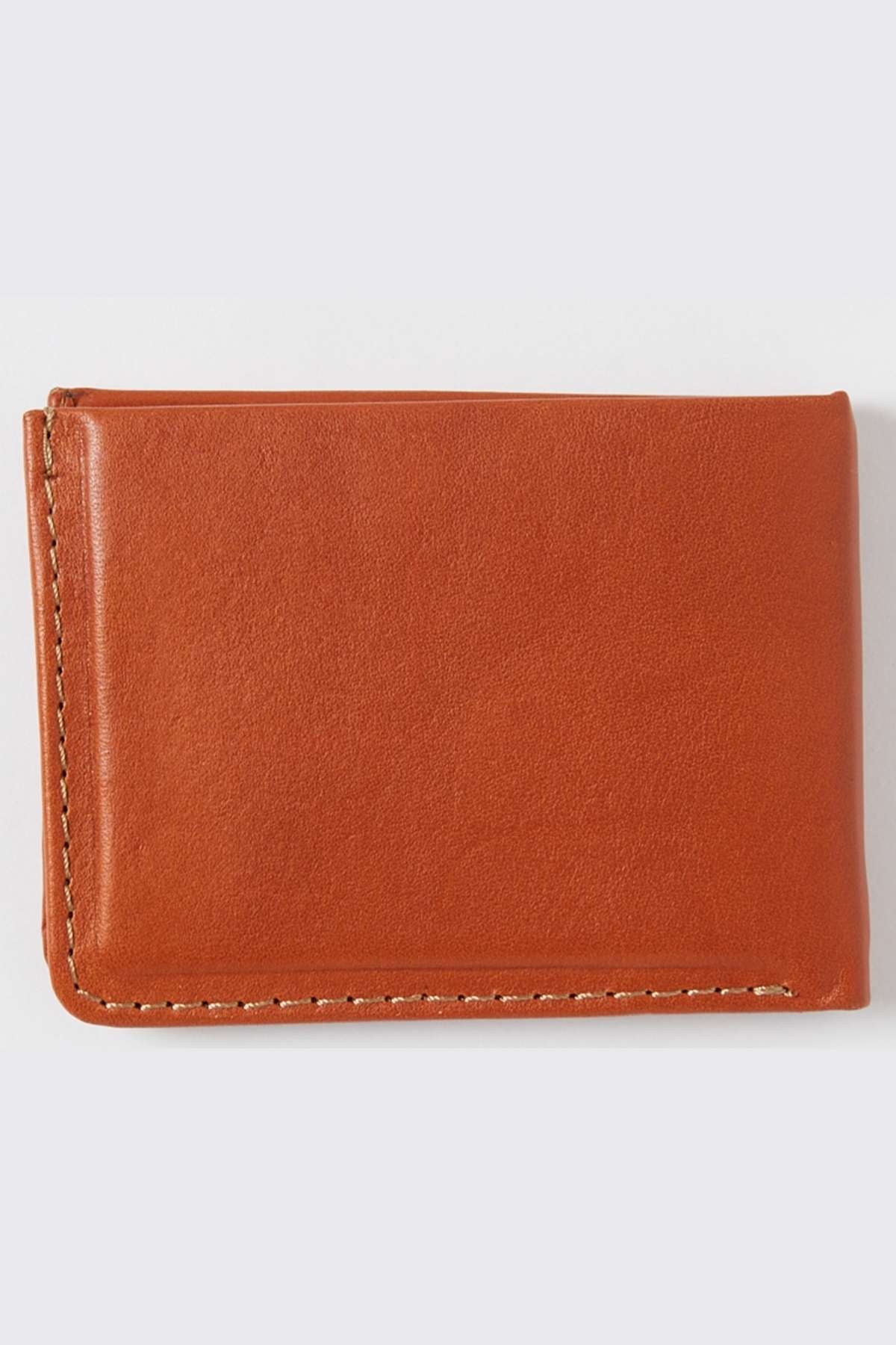 A closed Rip Curl Hi Rise RFID All Day Wallet, crafted from brown leather, sits on a light gray background. This wallet features a minimalistic design with visible stitching along the edges and offers RFID protection to secure your cards.