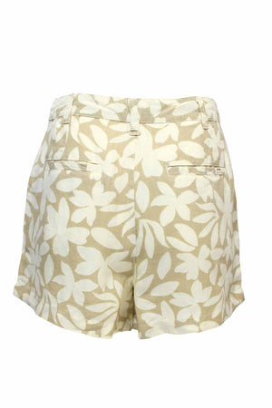 Rip Curl Holiday Tropics Short: Beige shorts made from linen and viscose, with a white floral yardage print. These high-waist shorts feature two back pockets and are set against a plain white background.