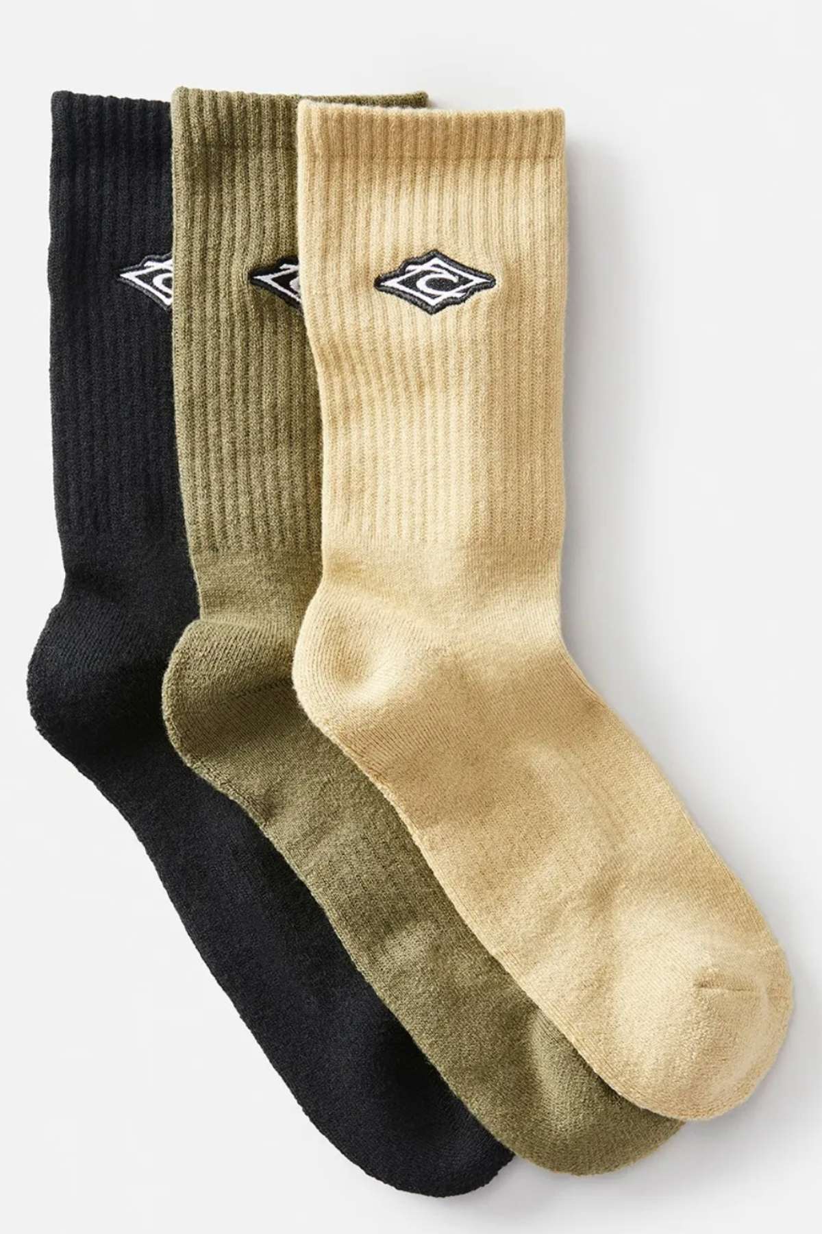 The Rip Curl Icons Crew Sock 3 Pack includes three pairs of ribbed crew socks in black, olive green, and beige. Each pair features an embroidered diamond-shaped logo and is crafted with an acrylic blend for superior comfort, neatly arranged to highlight their design and colors.
