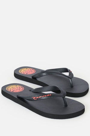 A pair of Rip Curl Icons Of Surf Bloom Open Toe Sandals in black, featuring a red and yellow circular logo on the heel and “Rip Curl” branding on the strap, displayed against a white background. Made with eco-friendly BLOOM algae foam, these sandals deliver comfort while promoting sustainable choices.