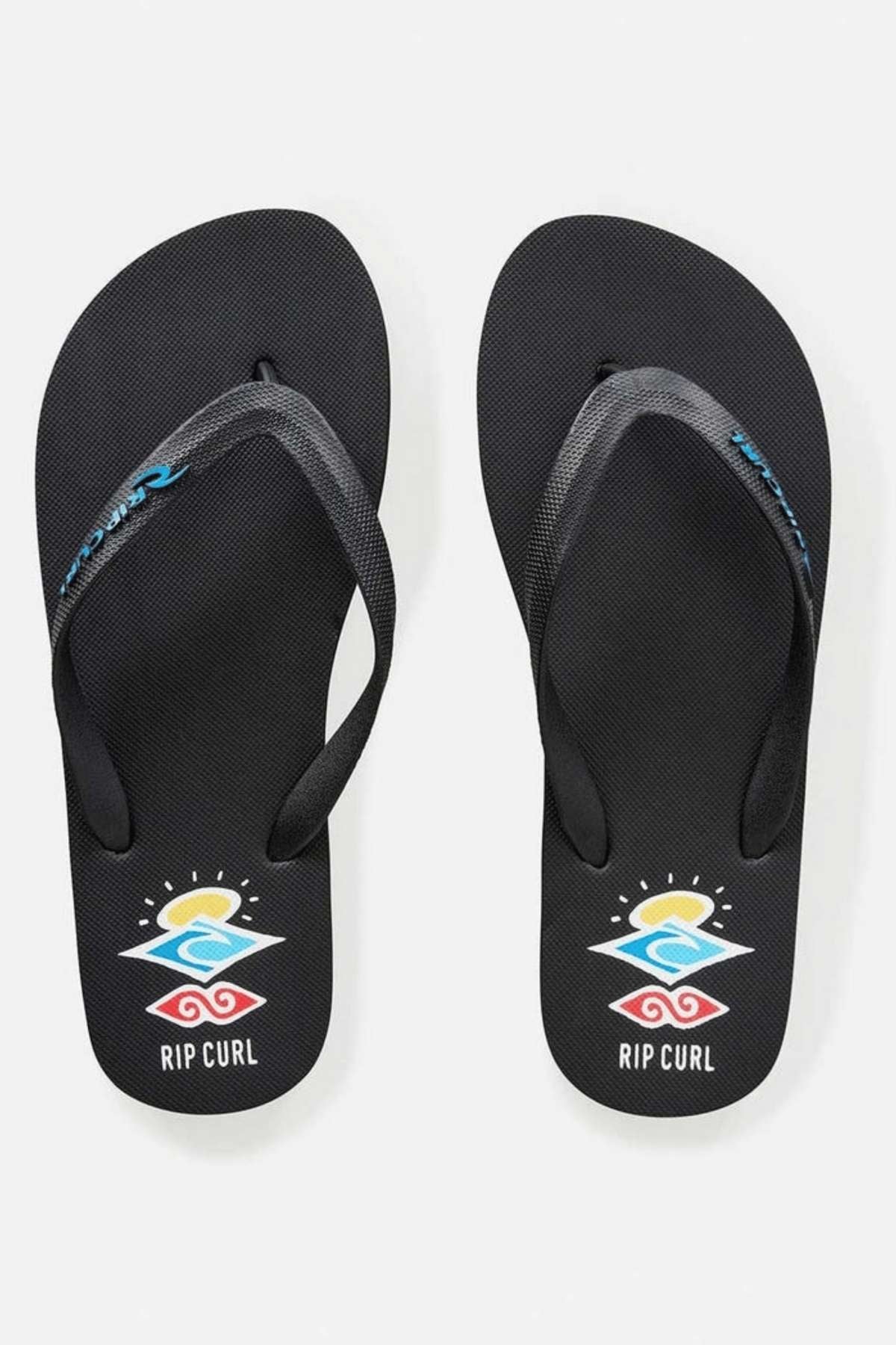 Introducing the Rip Curl Icons of Surf Bloom Thongs in black, adorned with a vibrant wave and sun design near the heel. The word "RIP CURL" is elegantly printed beneath the design, while the ergonomic molded straps proudly display the brand’s logo in blue and white.