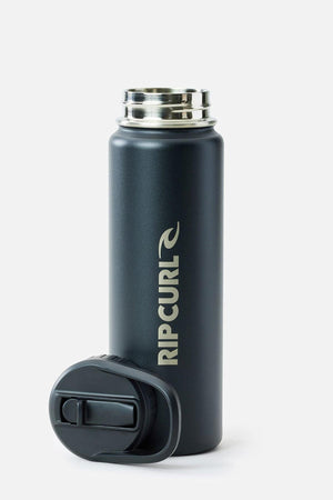 The Rip Curl Logo Drink Bottle 710ML is a matte black, double-walled stainless steel bottle with cream "RIP CURL" lettering, a silver rim, and a detached lid shown in front on a plain white background.