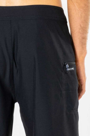A close-up of the back of a person wearing the Rip Curl Mirage Core Boardshort, highlighting a small zippered right-side pocket with a visible pull tag and detailed stitching.