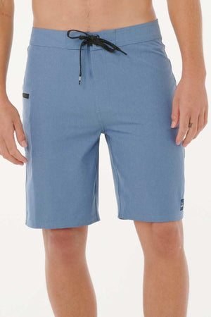 A person wearing Rip Curl Mirage Core Boardshorts in light blue with a black drawstring and a small right thigh pocket, standing against a plain white background.
