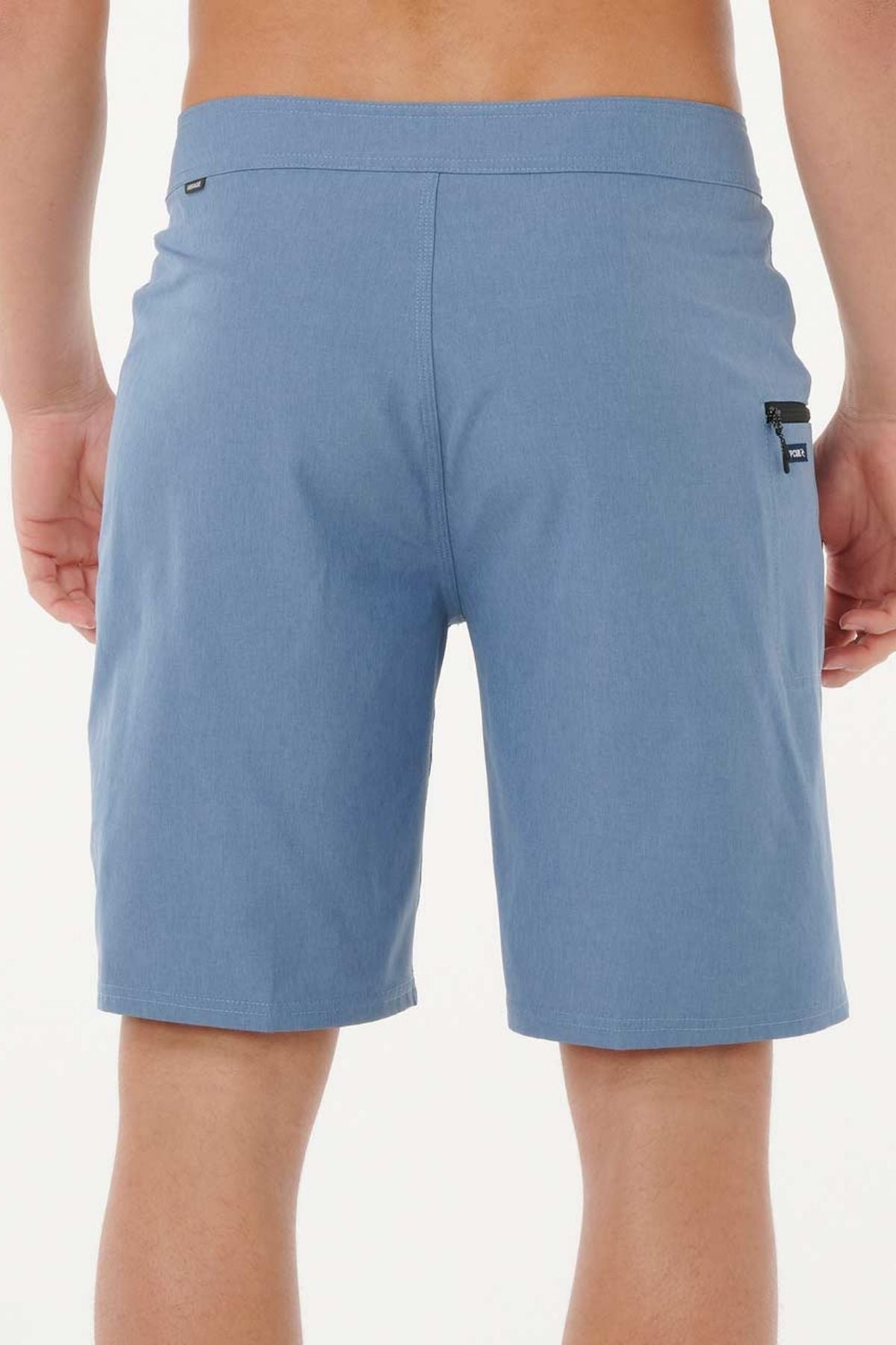 A person is shown from the waist down wearing Rip Curl Mirage Core Boardshorts in light blue, featuring a small zippered pocket on the right side against a plain white background.