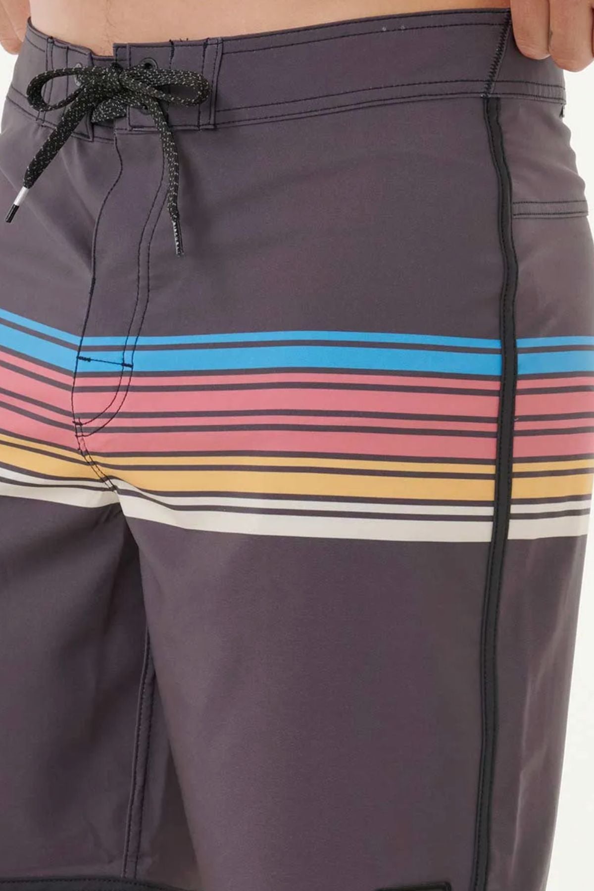 A close-up of a person wearing the Rip Curl Mirage Surf Revival 19" Boardshort in dark, quick-drying recycled PET, with blue, pink, orange, and white thigh stripes, black drawstrings, and side stitching.