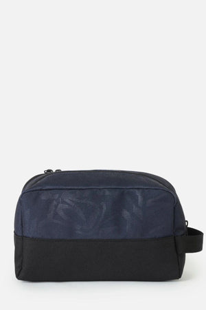 Rip Curl Archive Groom Toiletry Bag, a rectangular travel organiser with a navy blue patterned top section, a black bottom section, and a side carry handle.