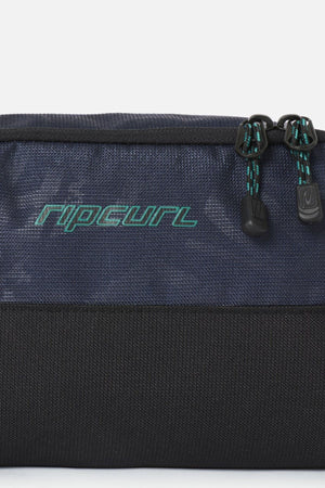 Rip Curl Archive Groom Toiletry Bag in navy blue and black with a teal logo and two zippered compartments, serving as a functional travel organiser.