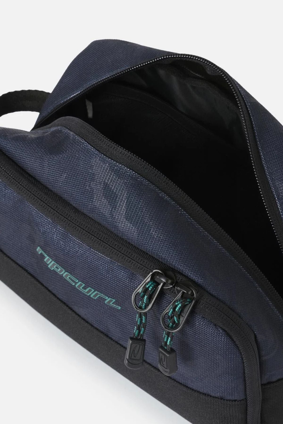 Rip Curl Archive Groom Toiletry Bag in navy blue with a black base, featuring a zippered top opening and a front pocket with two corded zipper pulls.