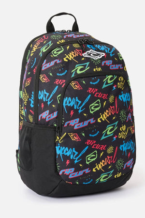 Rip Curl Ozone Boy 30L backpack in black with an all-over multicolored graffiti-style pattern of logos, lightning bolts, and suns, featuring a mesh side pocket and a top carry handle.