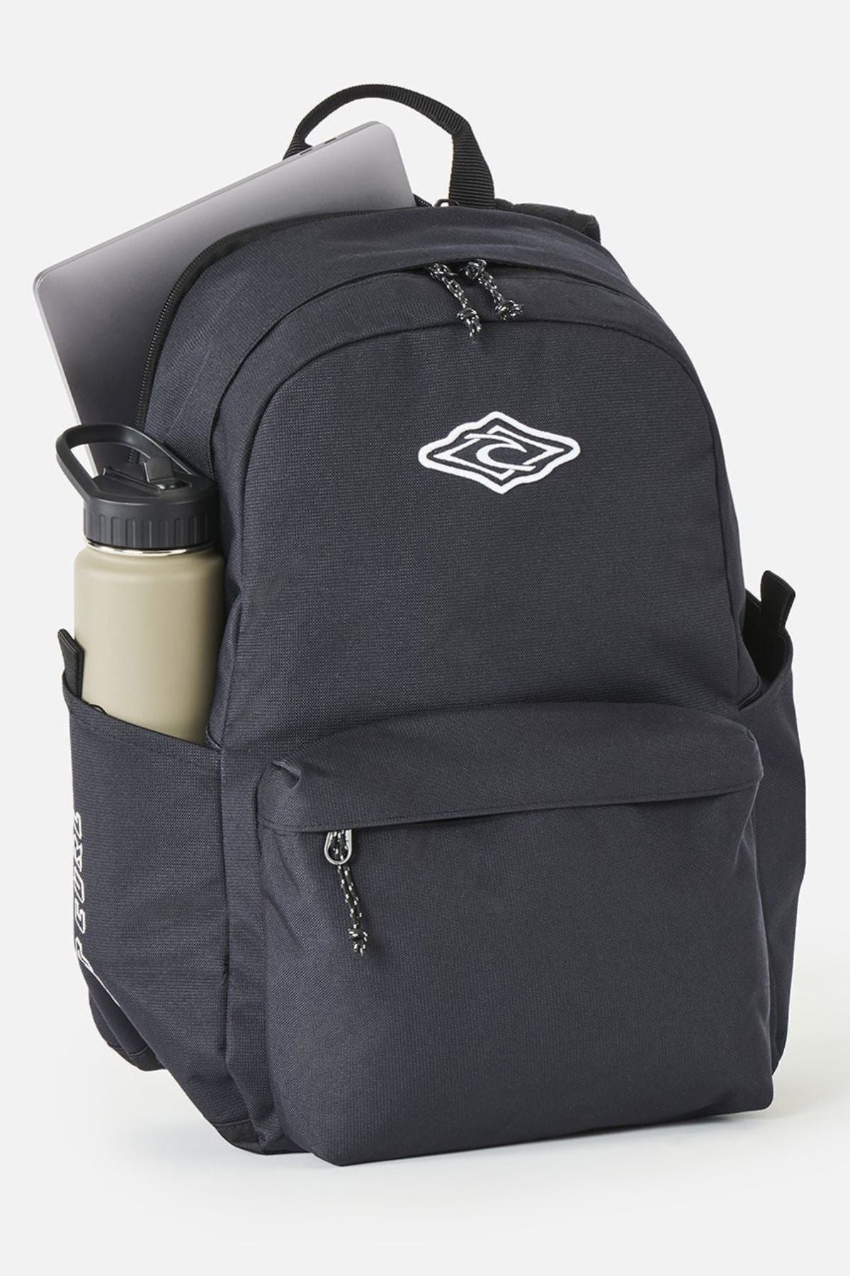 Rip Curl Crusher 30L Classic Backpack in black, featuring a front zip pocket, a water bottle in the side pocket, and a laptop stored in the main compartment.