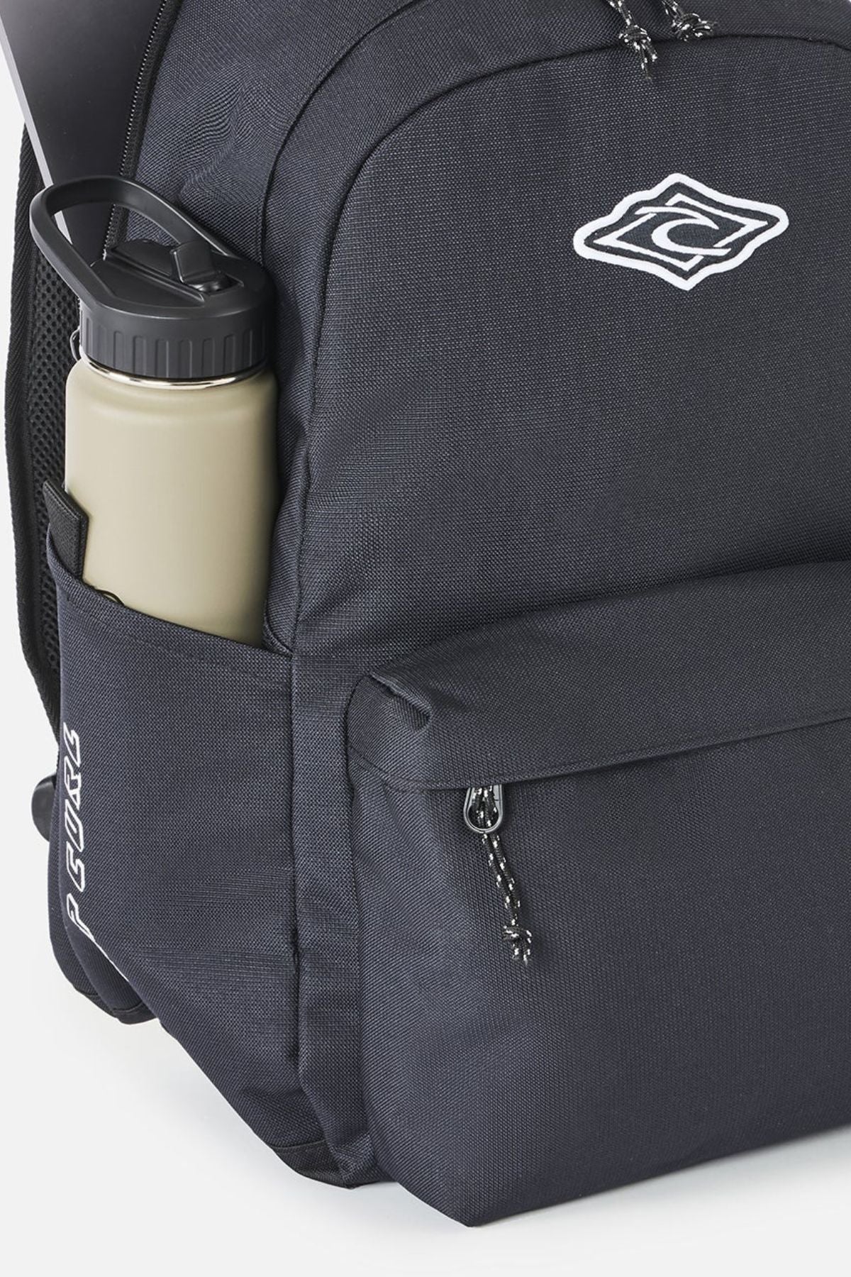 Black Rip Curl Crusher 30L Classic Backpack with a front zip pocket, a side water bottle sleeve containing a beige bottle, and a white graphic logo on the upper front.