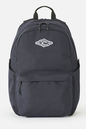 Black Rip Curl Crusher 30L Classic Backpack with a main zippered compartment, a front zippered pocket, side slip pockets, and a white diamond-shaped logo on the front.