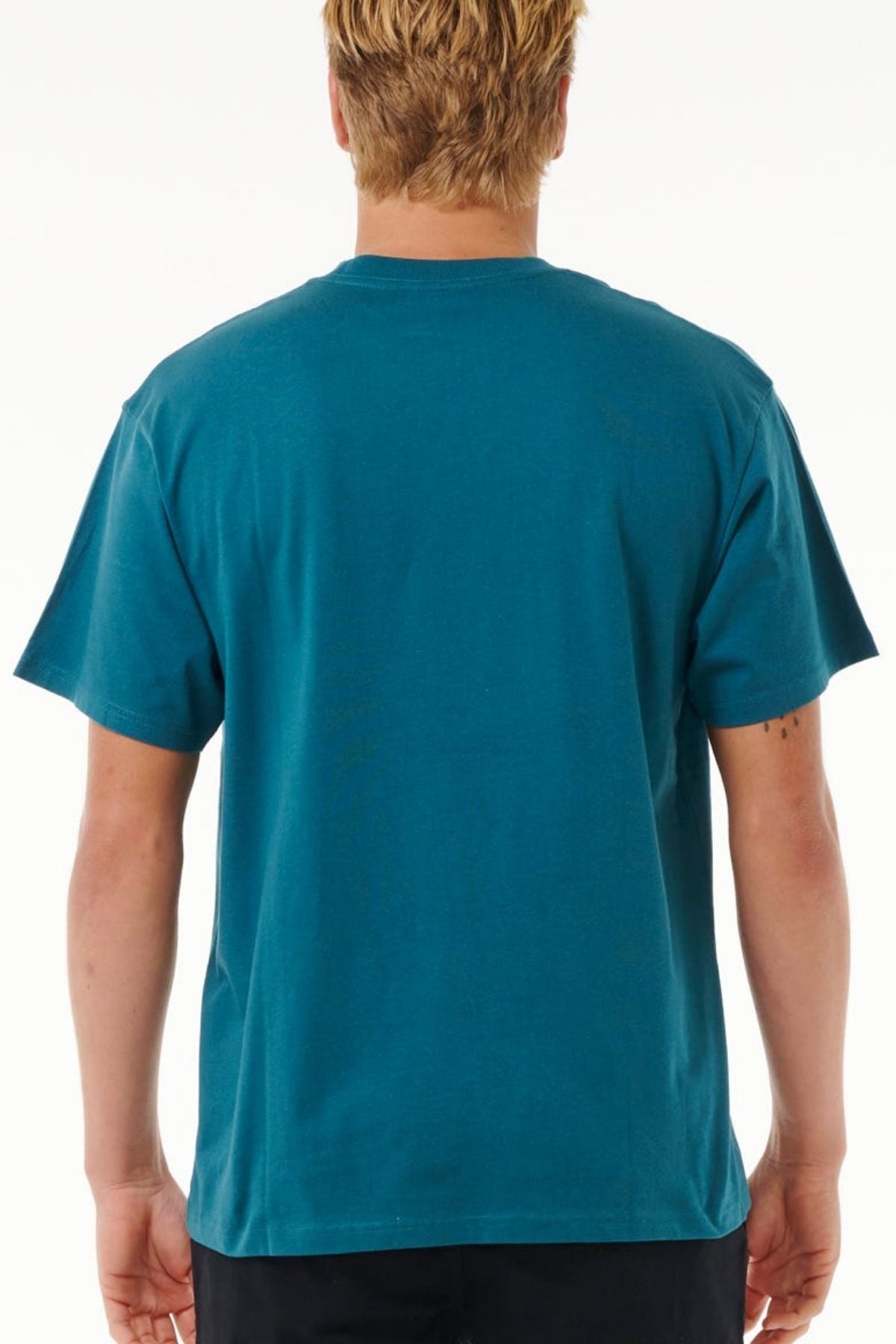 A person with short, light brown hair is shown from the back wearing a teal Rip Curl Pill Icon Tee and black pants, against a plain white background.