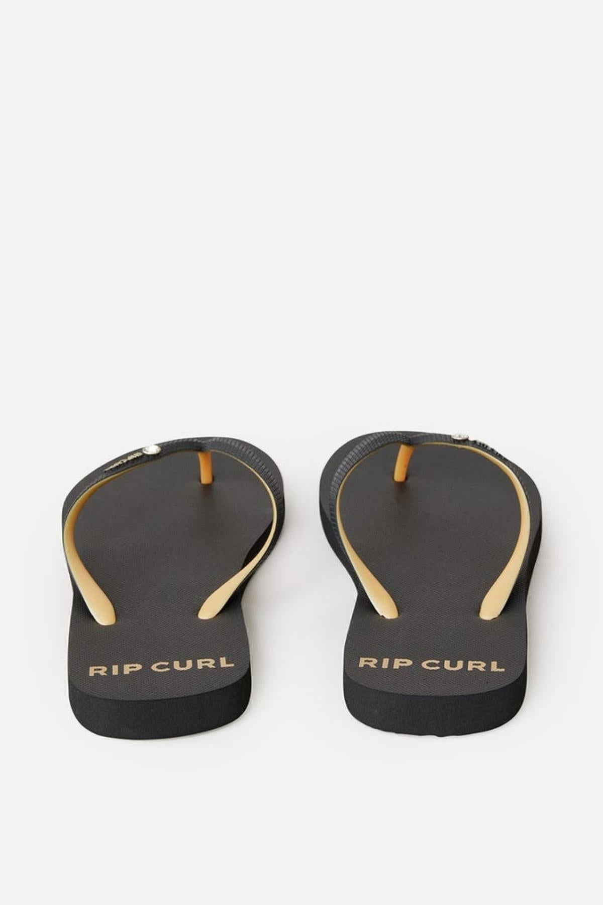 A pair of Rip Curl Premium Surf Bloom Thongs in black with yellow straps and the brand name "Rip Curl" printed on the heels. The thongs are positioned side by side, with the straps facing upward against a white background.