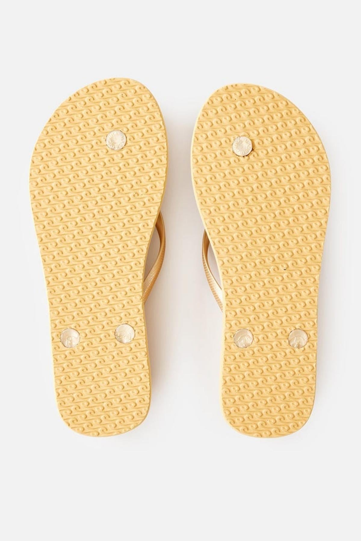 The Rip Curl Premium Surf Bloom Thongs are beige flip-flops featuring textured soles with three circular patterns on the bottom of each sandal. The beige straps, visible peeking from above the soles, are set against a neutral background.