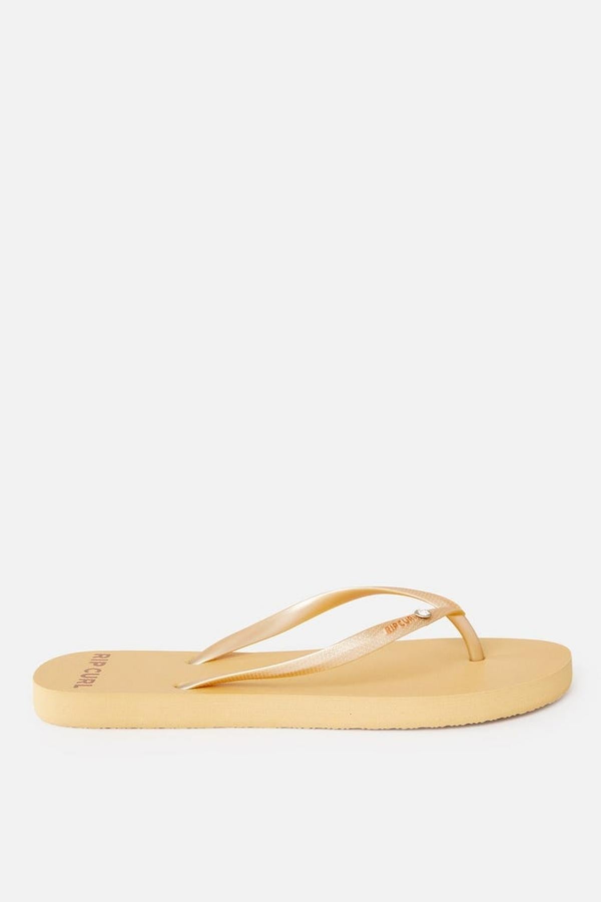 A single yellow thong with thin straps is shown against a plain white background. The straps have a subtle shine, and the sole appears to be made of rubber. The brand name "Rip Curl Premium Surf Bloom" is printed on one of the straps.