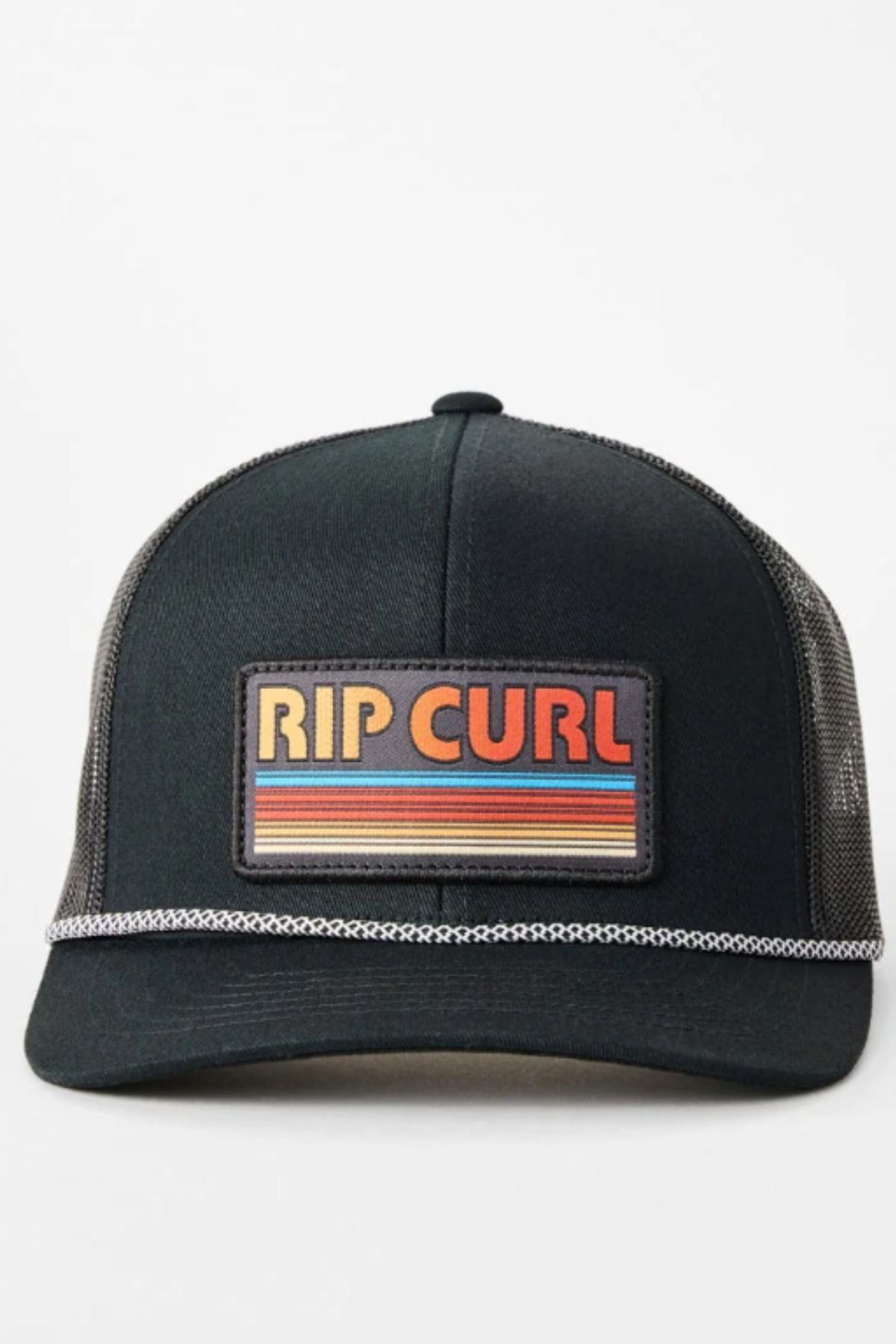 The Rip Curl Surf Revival Trucker is a black hat featuring mesh panels and a front rectangular patch with "RIP CURL" in bold, retro lettering over colorful horizontal stripes.