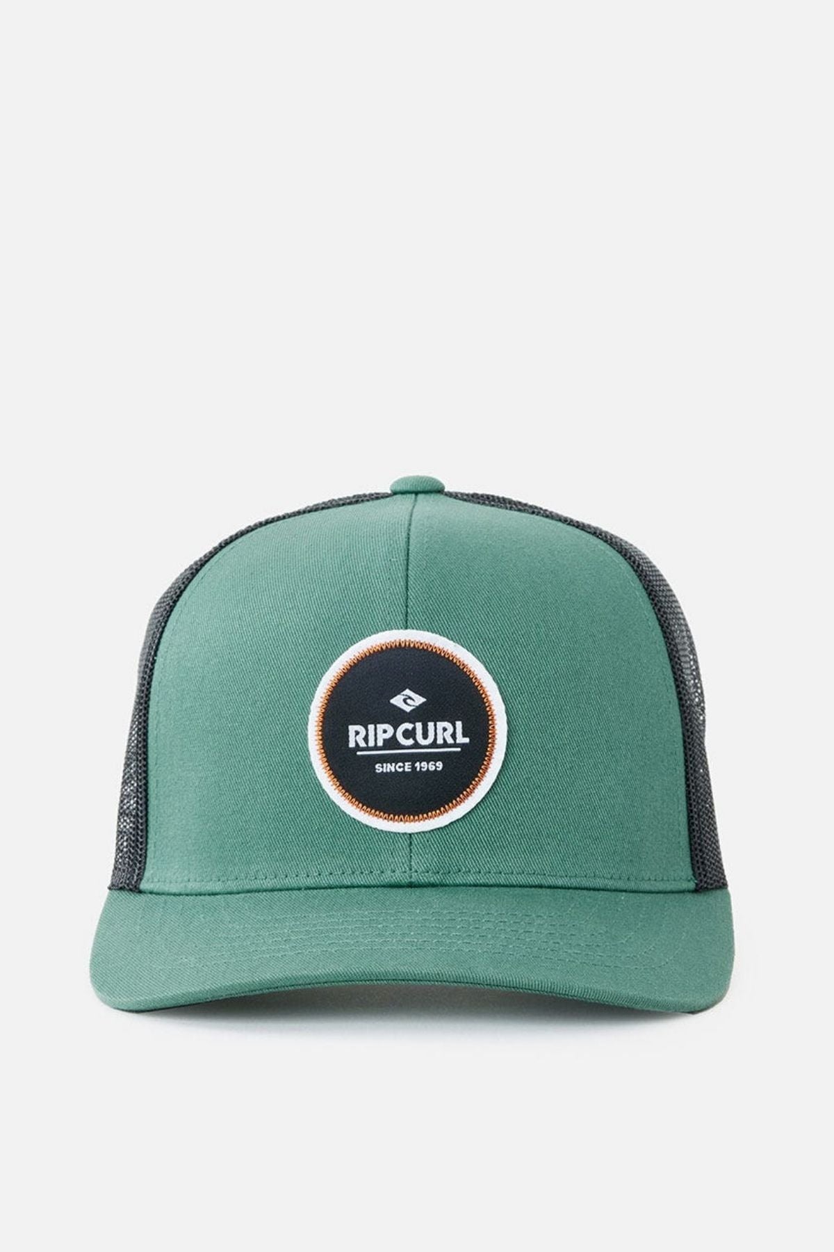 The Rip Curl Routine Curve Trucker is a green trucker cap with a black mesh back and a round logo patch on the front that reads "Rip Curl Since 1969," making it perfect for any outdoor activity.