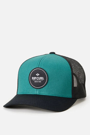 The Rip Curl Routine Curve Trucker hat features a teal and black design with a black mesh back, cotton twill front, center "Rip Curl" logo patch, curved brim, and structured crown for classic trucker style.