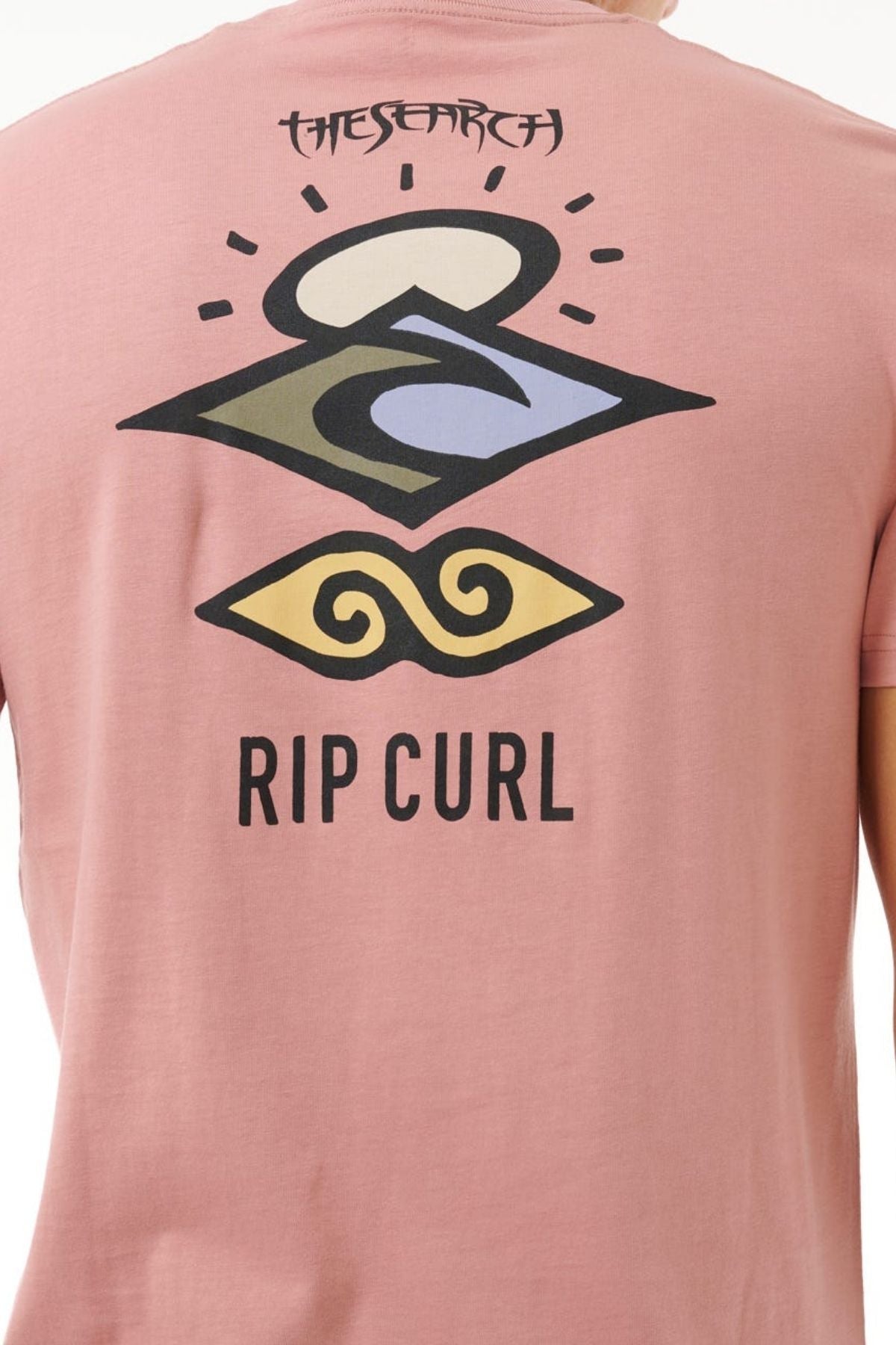 Back of the Rip Curl Search Icon Tee in pink, featuring abstract wave and sun graphics, "THE SEARCH" at the top, "RIP CURL" below. Made from soft Organic Cotton for all-day comfort.