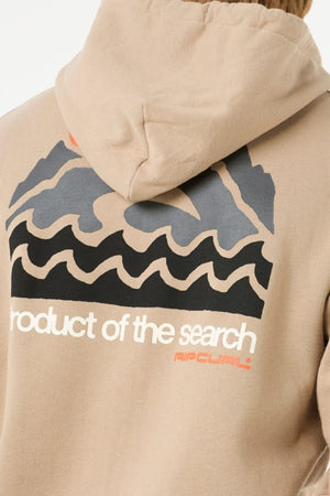 A person wearing a Rip Curl Search Zip Thru Hood, featuring a beige zip, stylized waves and mountains graphic on the back, and "product of the search" with "Rip Curl" in white and orange lettering.