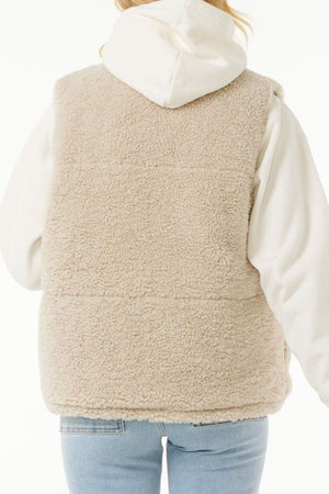 A person wearing the Rip Curl Soleil Revo Puffer Vest in cream over a white hoodie and light blue jeans, shown from the back against a white background.