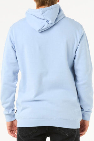 Facing away from the camera, a person wears a light blue Rip Curl Stapler Hood fleece hoodie and black jeans. The hood is up but not on their head, with a plain white background.
