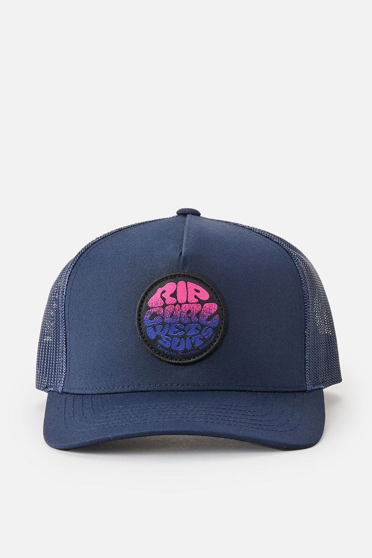 The Rip Curl Wetsuit Icon Trucker is a navy blue trucker cap made from recycled polyester, featuring mesh sides and back. The front is adorned with a circular embroidered patch that displays abstract pink and blue text, ideal for those who love designs reminiscent of Rip Curl Wetsuits.