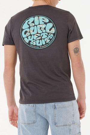 A person sports a casual look with the Rip Curl Wettie Passage Icon Tee—a dark shirt with a retro "Rip Curl Wet Suits" back graphic—paired with comfortable, standard-fit light blue denim jeans.