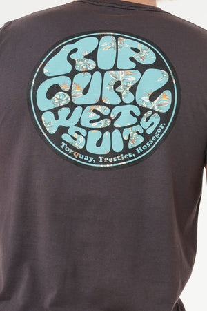 Wearing the Rip Curl Wettie Passage Icon Tee, which showcases a large, round "Rip Curl Wetsuits" floral graphic and "Torquay, Trestles, Hossegor" on the back—ideal for a casual look with its comfortable standard fit.