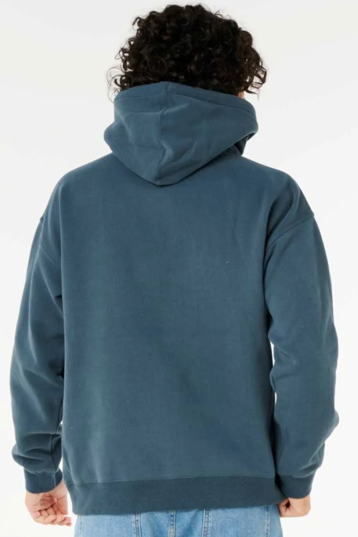 A person with curly hair is seen from behind, wearing a blue Rip Curl Dosed Up Hood made from responsibly sourced materials and light blue jeans, set against a plain white background.