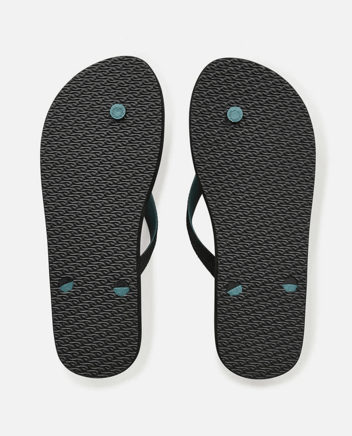 A pair of Rip Curl Breakers Bloom Thongs in black with BLOOM algae-blended foam, textured soles, and dark teal circular accents. They feature eco-friendly black straps, displayed on a plain white background.