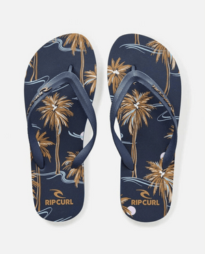 The Rip Curl Brush Palm Bloom Thongs feature a navy base with brown palm trees and abstract blue and white wave patterns. Crafted with an ergonomic strap and BLOOM™ algae foam, these thongs combine comfort and style for everyday adventures.