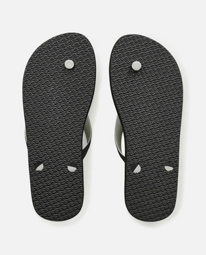 A pair of Rip Curl Flow Camo Bloom Thongs shown from the bottom, displaying textured soles with visible circular and triangular plugs where the ergonomic molded straps attach.
