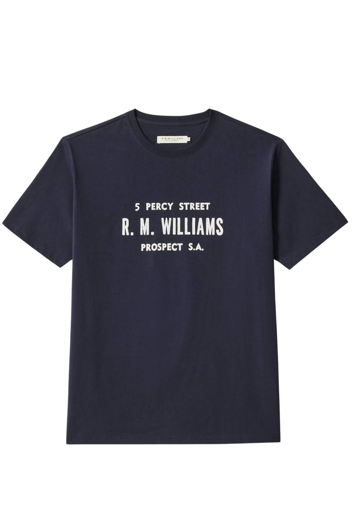 The RM Williams Bale T-Shirt is a navy blue regular-fit organic cotton tee with a front print reading "5 Percy Street R. M. Williams Prospect S.A." displayed on a plain white background.