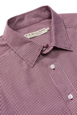 A close-up of the RM Williams Classic Shirt in maroon and white micro gingham check, featuring a button-up front, collar, and the R.M.Williams brand label sewn inside the neckline.