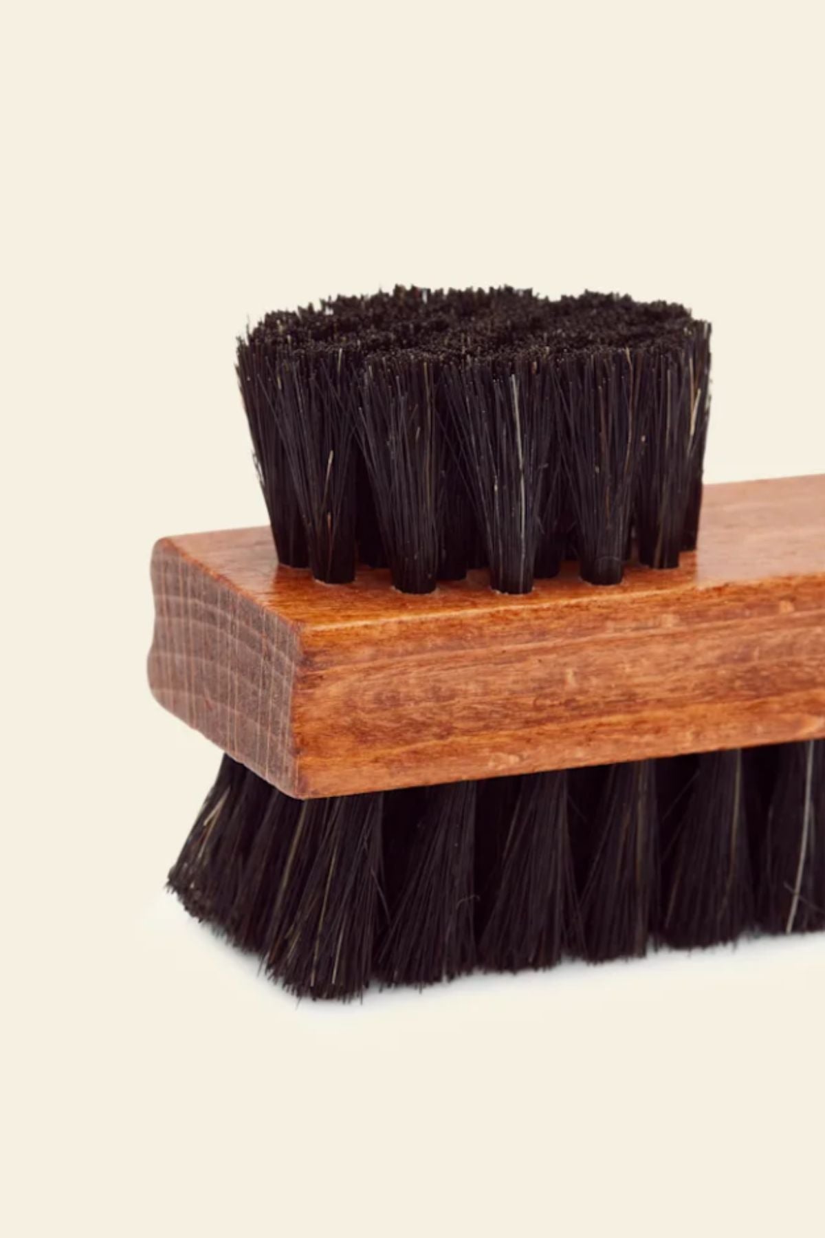 A close-up of the RM Williams Double Sided Brush with black bristles and a wooden handle, shown against a plain light background to display both the top and the bristles.
