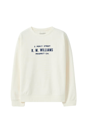 The RM Williams Heritage Brushed Sweatshirt features a cream brushed-back fabric, navy "5 Percy Street R. M. Williams Prospect S.A." text on the front, plus a ribbed crew neck and long sleeves for timeless comfort.