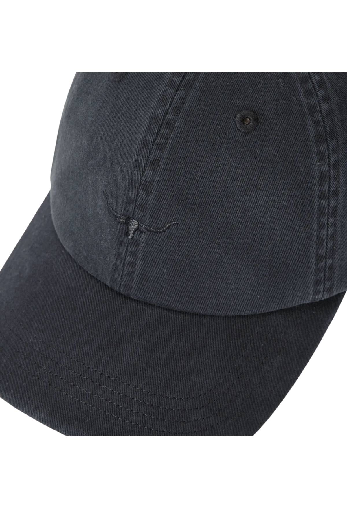 A close-up of the RM Williams Mini Longhorn Twill Cap, a black organic cotton baseball cap with visible stitching and a subtle embroidered longhorn skull outline on the front panel.