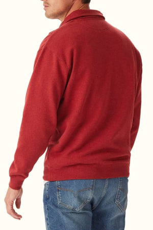A man is seen from the back, head turned slightly, wearing the RM Williams Mulyungarie Fleece in red and blue jeans against a plain light background.